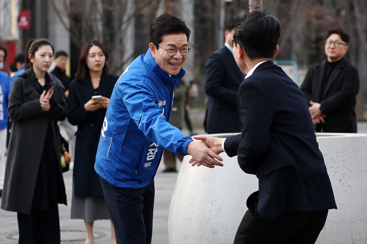 더불어민주당 정원오 서울시장 예비후보가 예비경선 투표 마지막 날인 지난 24일 서울 광화문광장에서 한 시민과 악수를 나누고 있다. 연합뉴스