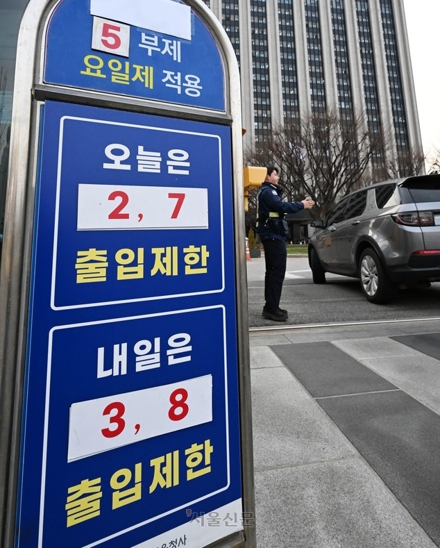 정부가 에너지 절약을 위해 25일부터 공공부문 ‘승용차 5부제(요일제)’를 의무화하기로 한 가운데 24일 정부서울청사 정문 차량 출입구 안내판에 오늘·내일 출입이 제한되는 차량 끝번호가 부착돼 있다. 홍윤기 기자