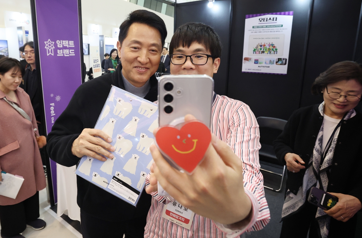 오세훈 서울시장이 26일 오후 서울 중구 동대문디자인플라자(DDP)에서 열린 ‘2026 소상공인 힘보탬 박람회’에서 소상공인과 기념사진을 찍고 있다. 2026.3.26. 뉴스1