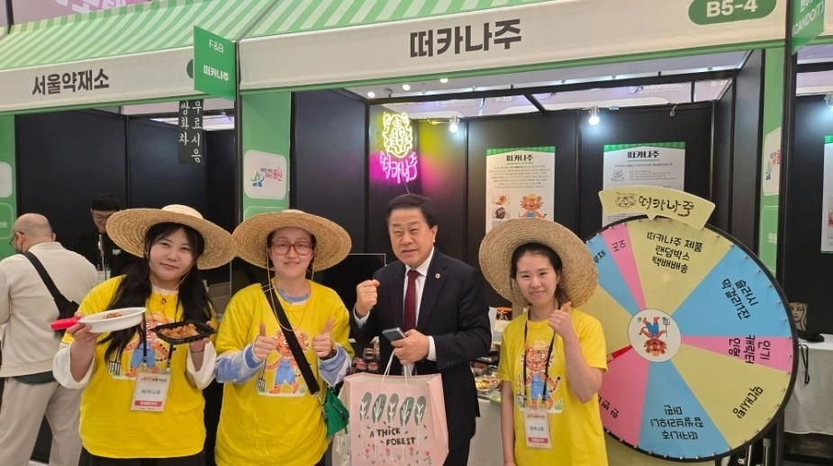 지난 26일 동대문디자인플라자(DDP)에서 개최된 ‘2026 소상공인 힘보탬 박람회’에 참석한 김용호 서울시의원(오른쪽 두 번째)이 용산구에서 가게를 운영하고 있는 떠카나주 매장에서 제품을 구매한 후 직원들과 기념촬영을 하고 있다.