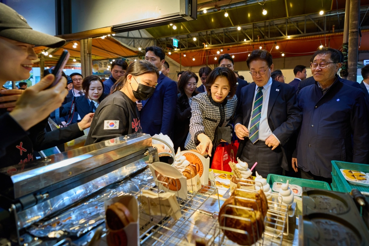 이재명 대통령이 30일 제주 타운홀미팅을 마친 뒤 김혜경 여사와 함께 제주시 동문시장을 찾아 간식을 구매하고 있다. 2026.3.30. 청와대 제공