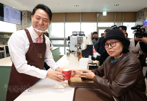 오세훈(왼쪽) 서울시장이 30일 서울 서초 시니어플라자 늘봄카페에서 직접 제조한 커피를 시민에게 전달하고 있다. 도준석 전문기자