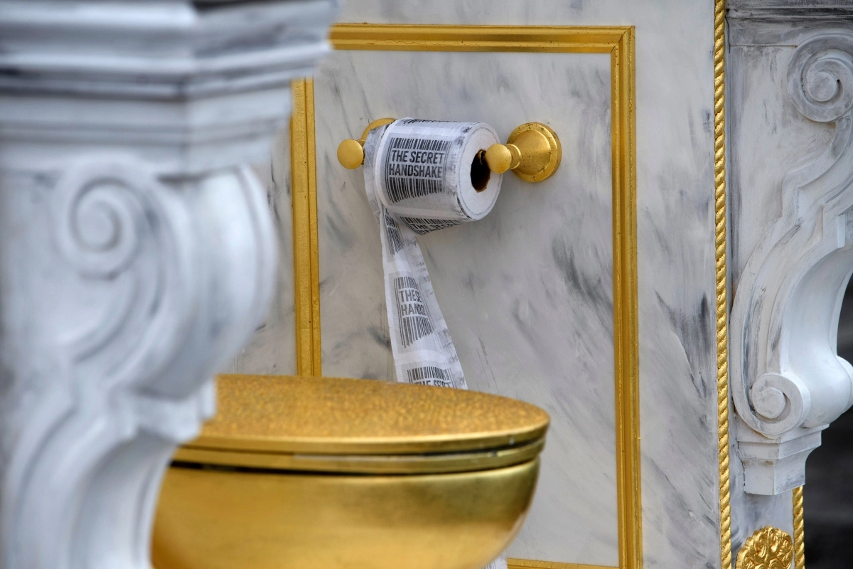 30일(현지시간) 미국 워싱턴DC 내셔널 몰에 설치된 ‘왕에게 어울리는 왕좌’(A throne fit for a king)라는 제목의 황금 변기 옆에 ‘시크릿 핸드셰이크’가 인쇄된 두루마리 화장지가 걸려 있다. 이 변기는 게릴라 예술그룹 ‘시크릿 핸드셰이크’가 만든 것으로 백악관 리모델링에 집착하는 도널드 트럼프 대통령을 조롱하는 작품이다. 2026.03.31. AP 뉴시스