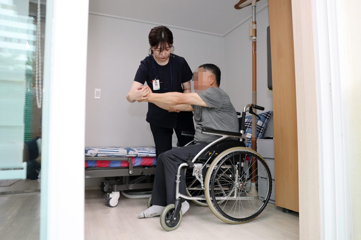 광주 광산구 ‘살던집 프로젝트’ 기반 시설인 ‘중간집’에서 생활하는 주민이 작업 치료사의 도움으로 재활 운동을 하고 있다. 광주 광산구 제공