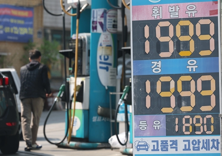 이재명 대통령이 서울 여의도 국회에서 26조 2000억원 규모의 ‘전쟁 추경’ 관련 시정연설을 한 2일 서울의 한 주유소에 ℓ당 2000원에 육박한 휘발유·경유 가격 안내문이 놓인 가운데 시민들이 주유를 하고 있다. 연합뉴스