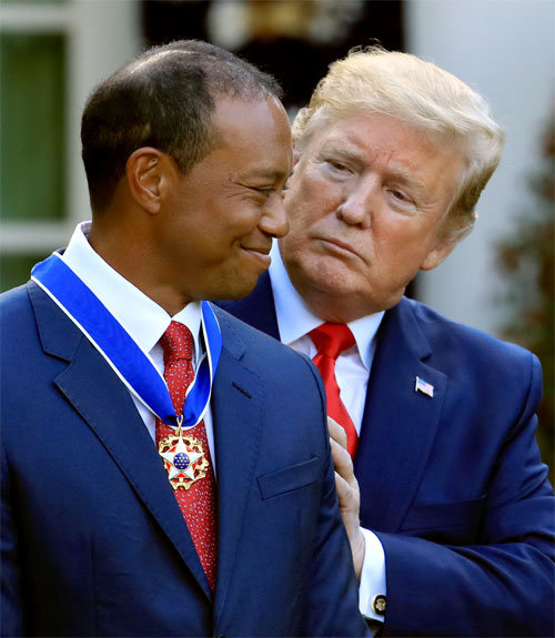 도널드 트럼프(오른쪽) 미국 대통령이 2019년 5월 7일 백악관에서 타이거 우즈의 목에 대통령 자유 메달을 걸어준 뒤 어깨를 감싸 쥐며 격려하고 있다. 워싱턴 AP 뉴시스