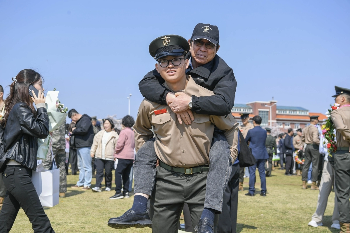 지난 2일 경북 포항 해병대 교육훈련단 연병장에서 열린 신병 1327기 수료식에서 해병대 최초 4대 해병 가족이 된 김준영 이병이 2대 해병인 할아버지 김은일씨를 업고 기념사진을 촬영하고 있다. 해병대사령부 제공