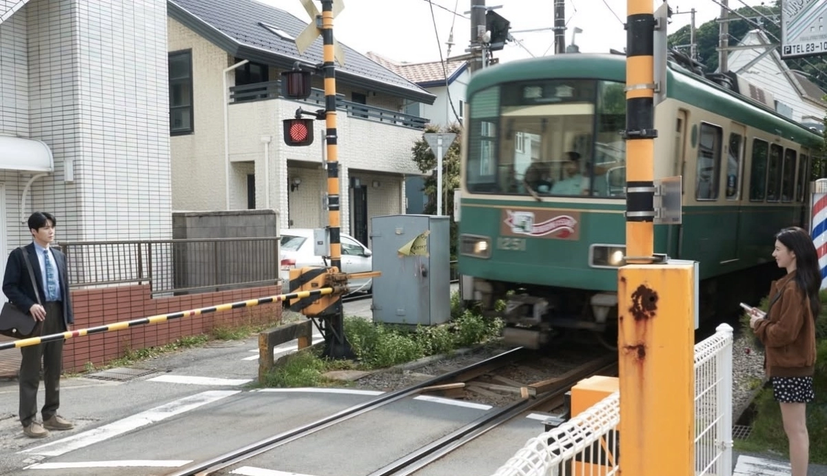배우 김선호(왼쪽), 고윤정 주연의 넷플릭스 드라마 ‘이 사랑 통역 되나요?’에 등장한 일본 가나가와현 가마쿠라시의 에노시마전철(에노덴) 철길 건널목. 넷플릭스 인스타그램 캡처