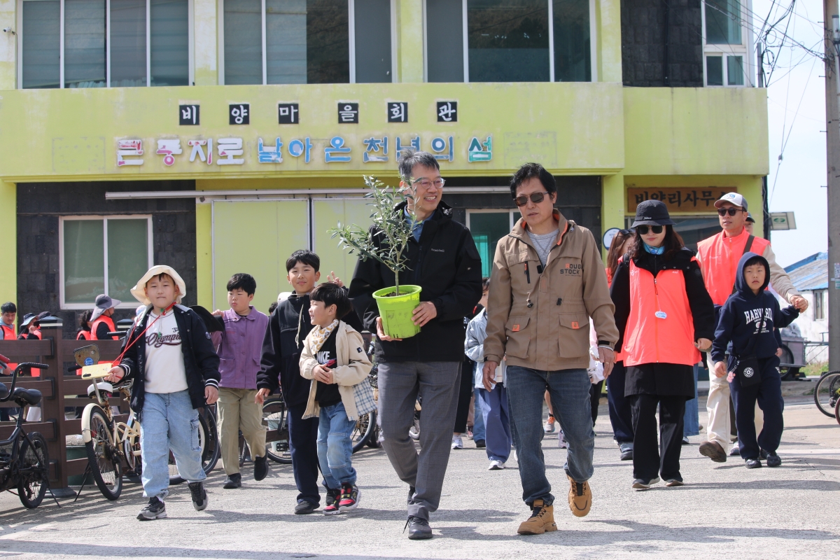 드론 배송된 올리브 묘목을 운반하는 이영근 한국관광공사 제주지사장(앞줄 왼쪽)과 고성민 비양리 이장(오른쪽). 한국관광공사 제공.