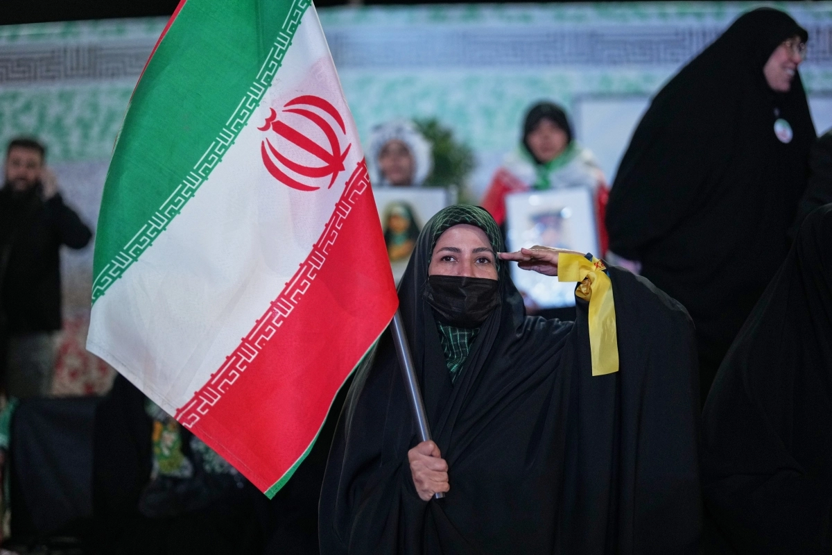 5일(현지시간) 이란 수도 테헤란에서 한 여성이 이란 국기를 들고 거수경례를 하며 서 있다. 2026.4.5 테헤란 AP 뉴시스