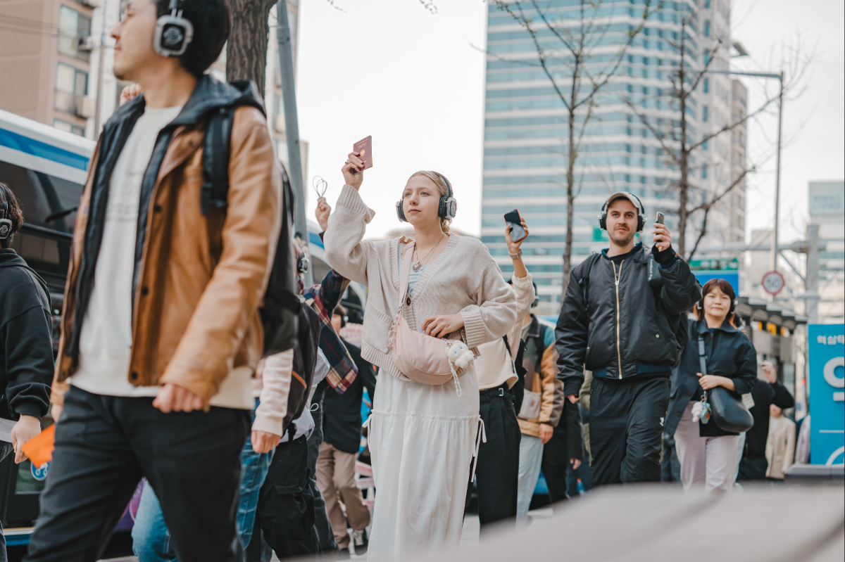 3일 ‘리모트 서울’ 참여자들이 인공지능(AI) 음성 안내에 따라 거리를 거닐고 있다. 헤드폰에선 집회 현장의 소리가 흘러나와 마치 행렬에 참가한 듯한 느낌을 주면서 도시와 사회의 구성, 민주주의의 효용에 대해 이야기한다. GS아트센터 제공