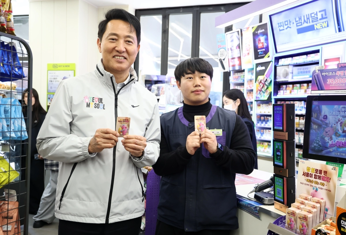 오세훈(왼쪽) 서울시장이 7일 종로구 CU 마로니에 공원점에 비치된 ‘외로움 없는 서울’ 포토카드를 들어 보이고 있다. 포토카드 뒷면 QR코드를 인식하면 ‘외로움 안녕 120’ 등 고립 운둔 청년을 돕는 서비스로 연결된다. 연합뉴스