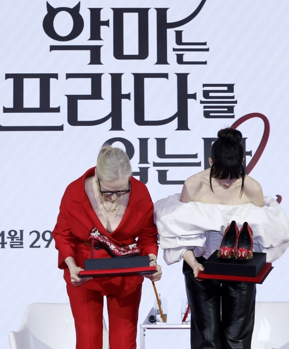 배우 메릴 스트립(왼쪽), 앤 헤서웨이가 8일 서울 종로구 포시즌스 호텔에서 열린 영화 ‘악마는 프라다를 입는다2’ 내한 기자간담회에서 관계자에게 꽃신 선물을 받고 고개 숙여 인사하고 있다. 2026.04.08.<br>뉴시스