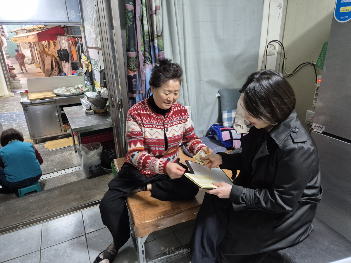 제주 서문시장 상인 신희선(왼쪽)씨가 8일 하나새마을금고 파출 수납을 이용하고 있다.