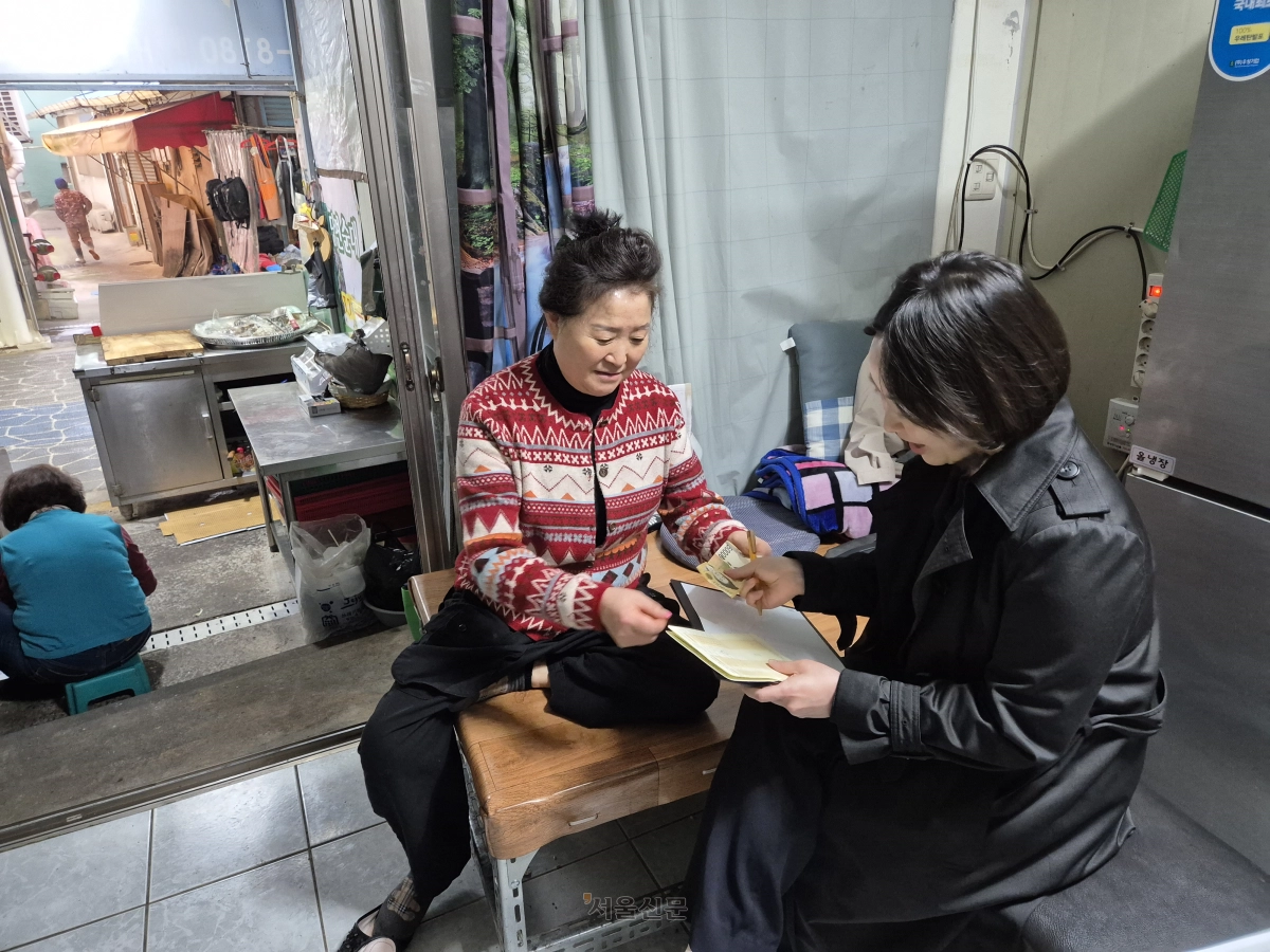 제주 서문시장 상인 신희선(왼쪽)씨가 8일 하나새마을금고 파출 수납을 이용하고 있다.