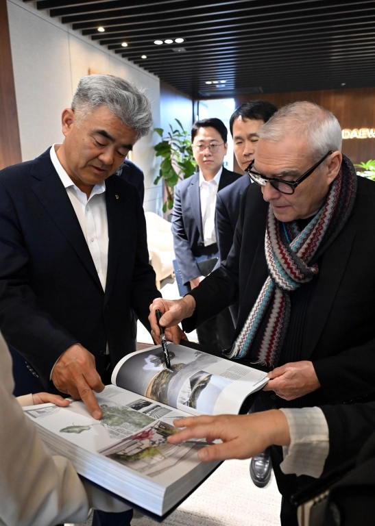 도미니크 페로(오른쪽)가 자신의 작품집 중 여수 장도 설계에 대해 정원주 대우건설 회장에게 설명하고 있다. 대우건설 제공