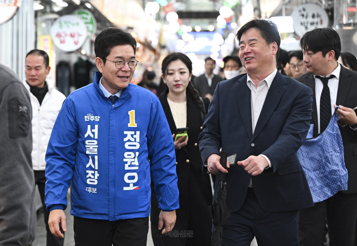 더불어민주당 서울시장 후보로 확정된 정원오(왼쪽) 전 서울 성동구청장이 9일 민주당을 상징하는 파란색 점퍼를 입고 민생 현장 목소리를 듣기 위해 서울 중랑구 동원시장을 둘러보고 있다. 이지훈 기자