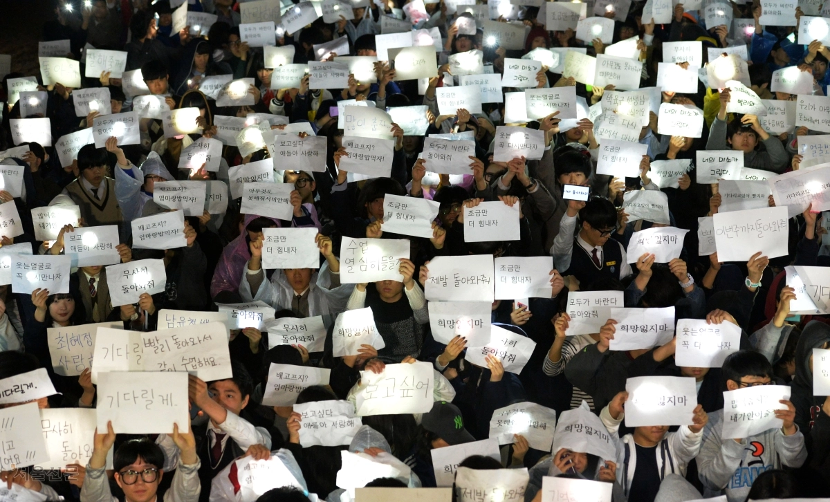 17일 경기도 안산시 고잔동 단원고등학교 운동장에서 1, 3학년 재학생들과 주변 학교 학생들이 비 내리는 날씨에 촛불 대신 스마트폰 불빛으로 각종 문구를 비춘 채 제주도 수학여행길에 올랐다 진도 해상에서 여객선 침몰 사고로 실종된 2학년 학생들이 무사히 돌아오길 바라는 행사를 열고 있다. 2014. 4. 17 손형준 boltagoo@