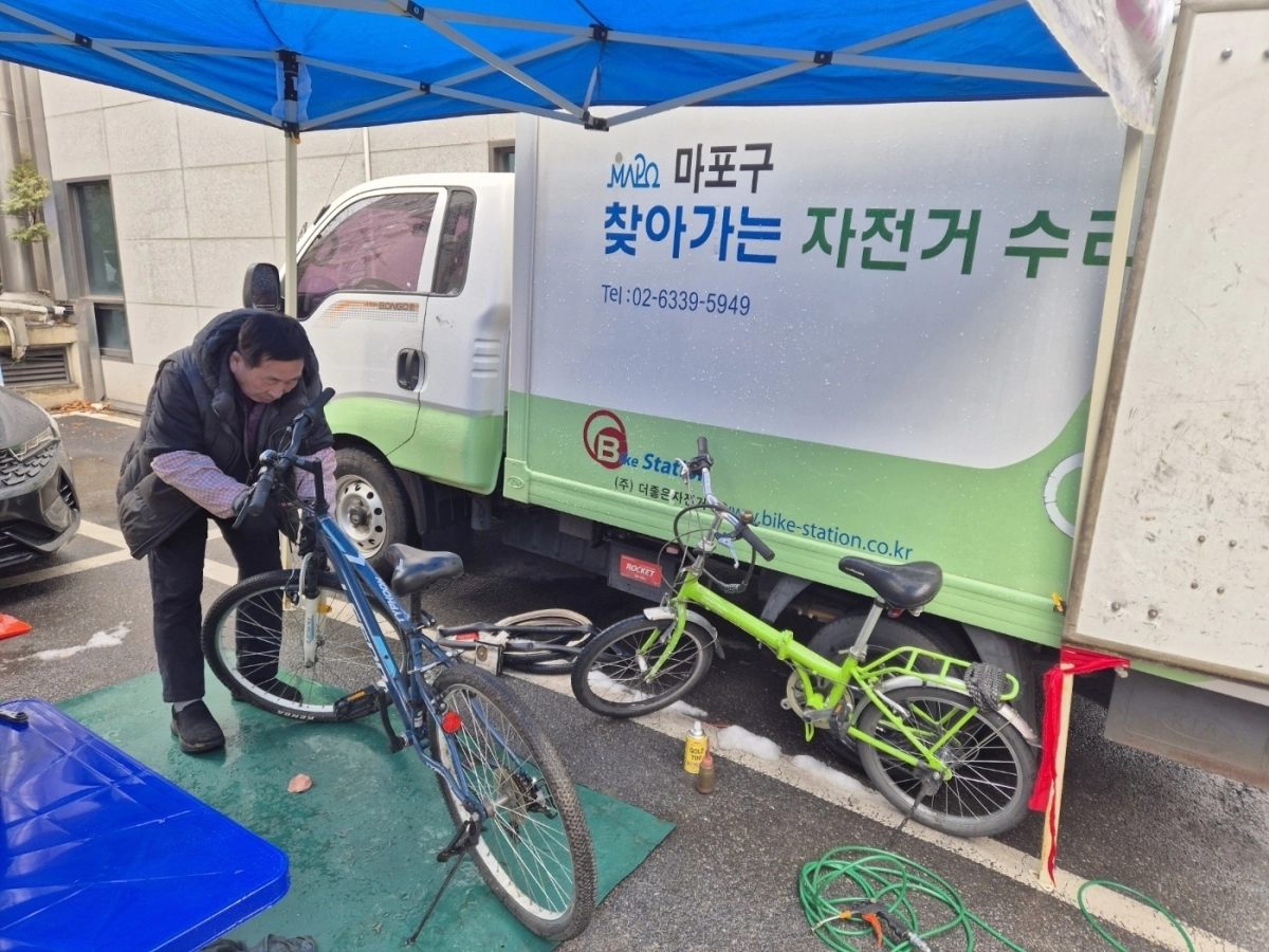 서울 마포구가 운영하는 찾아가는 자전거 수리센터에서, 자전거 전문가가 수리를 하고 있다. 마포구 제공