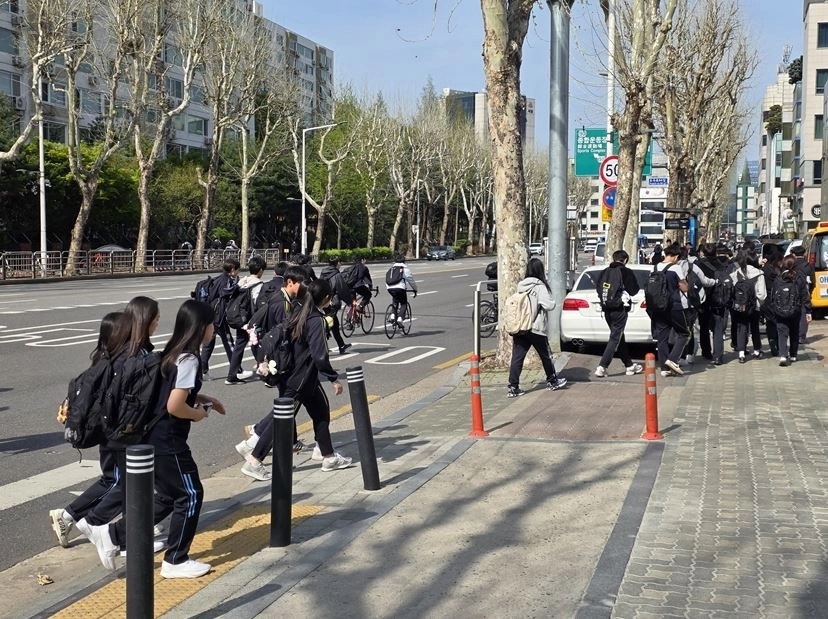 자전거도로에 불법 주차 차량으로 인해 도로를 통해 이동하는 학생들