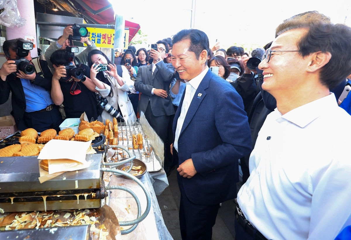 정청래(오른쪽 두 번째) 더불어민주당 대표와 부산시장 후보인 전재수(맨 오른쪽) 의원이 15일 부산 부산진구 부전시장의 한 붕어빵 가게에서 환하게 웃으며 상인과 이야기를 나누고 있다. 부산 연합뉴스