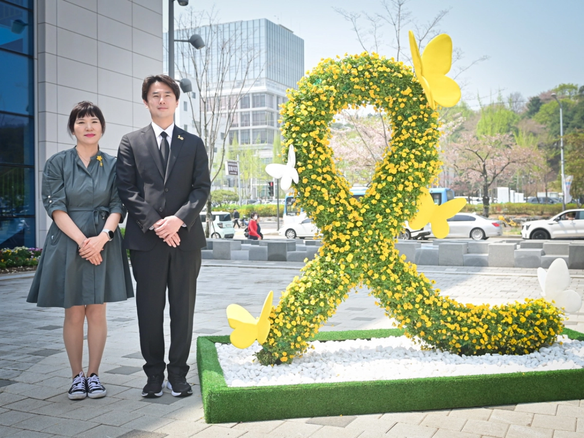 황대호 의원이 15일 4.16생명안전교육원 야외 광장에서 이지성 4.16기억저장소 소장과 함께 세월호 참사를 상징하는 노란 리본 조형물 앞에서 기념 촬영을 하고 있다.(사진=경기도의회)