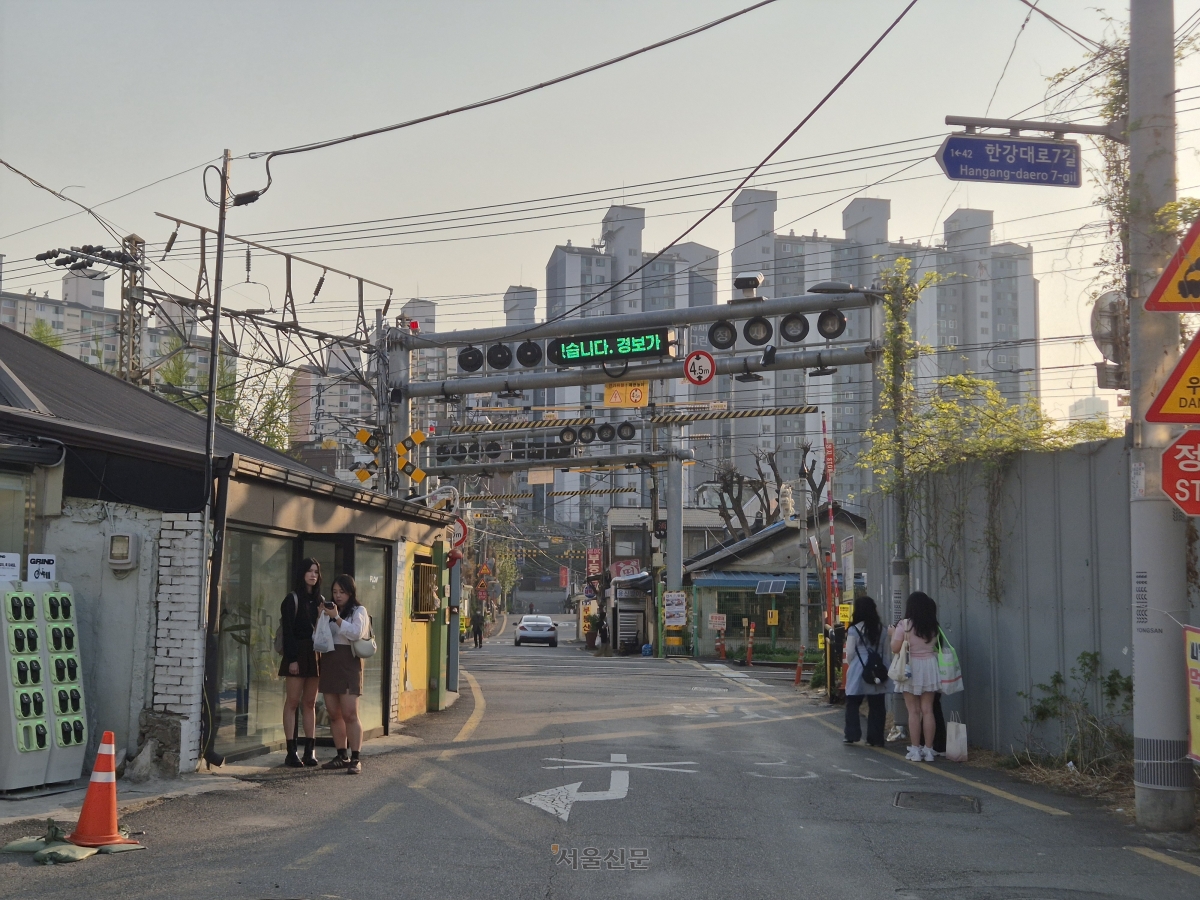 지난 14일 서울 용산구 한강로3가 백빈건널목에서 여행객들이 사진을 찍고 있다.  드라마 ‘나의 아저씨’로 전 세계적으로 유명해진 장소다.  서유미 기자