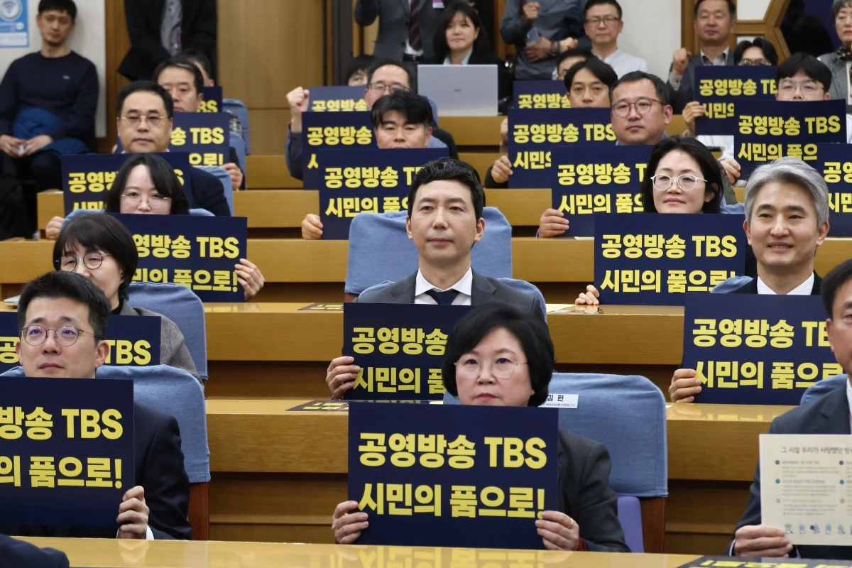 이정헌(앞에서 두 번재줄 가운데) 더불어민주당 의원이 지난달 30일 국회 의원회관에서 열린 <꺼지지 않는 스튜디오: 마지막 불빛을 지키는 사람들> 상영회에 참석해 피켓을 들어 올리고 있다. 이정헌 의원실 제공