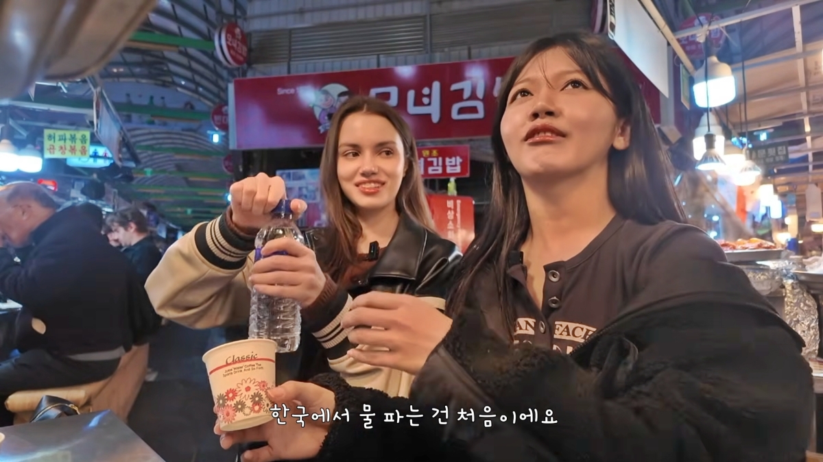 한국 생활 13년 차인 미얀마 출신 유튜버 ‘카잉’은 16일 러시아인 친구와의 서울 광장시장 방문기를 공개했다. 이들은 광장시장의 한 노점에서 만두와 잡채, 소주 한 병을 주문했다. 이 과정에서 물 한잔을 요청하자, 상인은 물값 2000원을 따로 요구했다. 2026.4.16 유튜브 채널 ‘카잉’ 화면