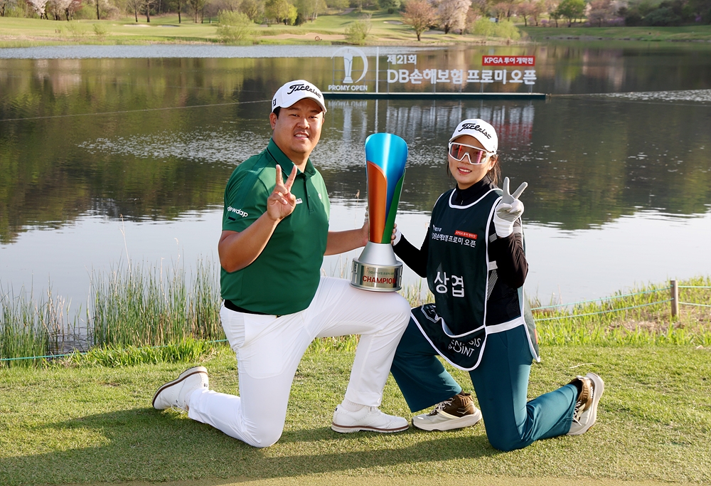 이상엽(왼쪽)이 19일 강원 춘천시 라비에벨 골프앤리조트 올드코스에서 열린 ﻿KPGA 투어 개막대회 DB손해보험 프로미오픈에서 우승한 뒤 캐디로 참여한 여자친구와 함께 트로피를 들고 기념촬영을 하고 있다. KPGA 제공