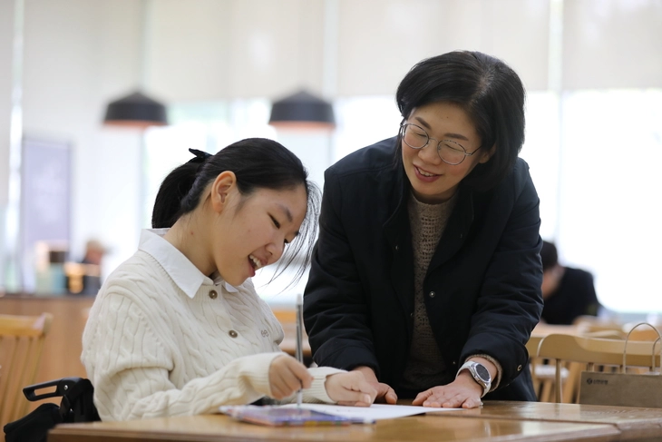 권은영(왼쪽)양이 어머니 노효선씨 곁에서 디즈니 애니메이션 ‘겨울왕국’의 캐릭터 올라프를 그리고 있다. 푸르메재단 제공
