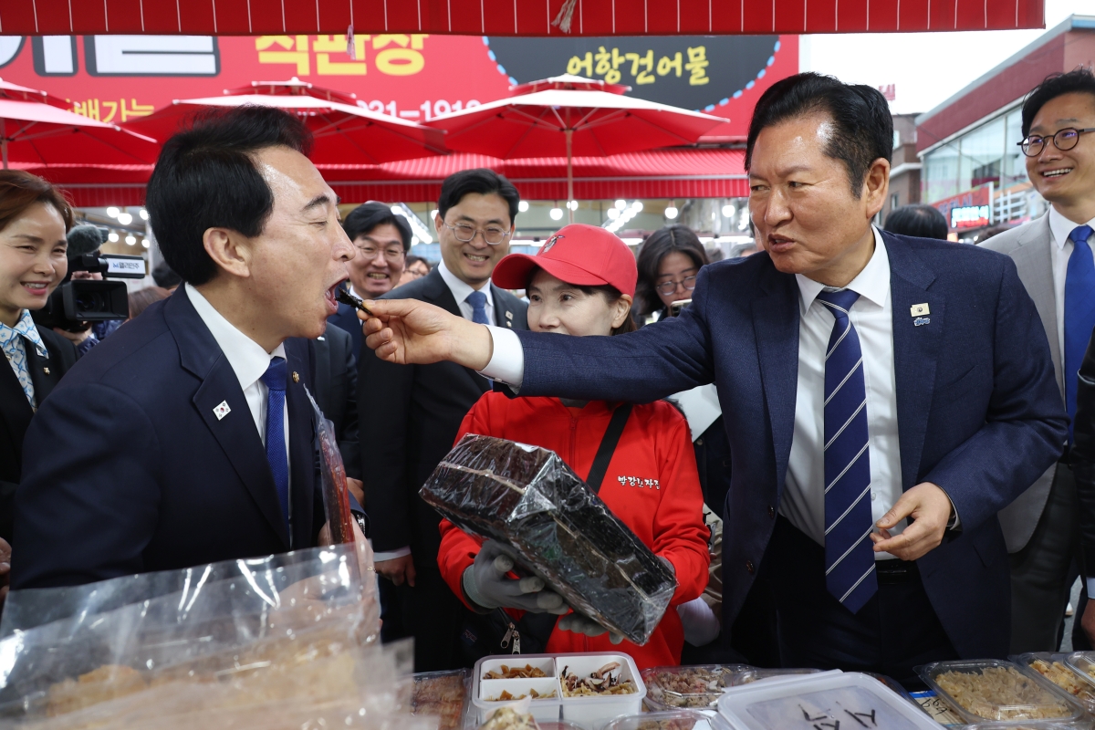 정청래(오른쪽) 더불어민주당 대표가 20일 충남 보령시 대천항수산시장을 방문해 충남지사 후보인 박수현 의원에게 김을 먹여 주고 있다. 보령 연합뉴스