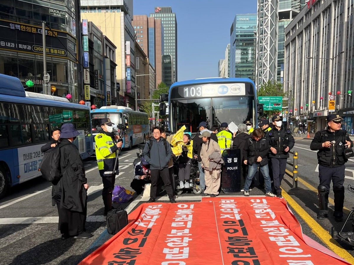 전국장애인차별철폐연대(전장연) 활동가들이 21일 서울 도심 종각역 일대에서 저상버스 도입 등을 주장하며 ‘버스 저지 시위’를 벌이고 있다. 전장연 페이스북 캡처