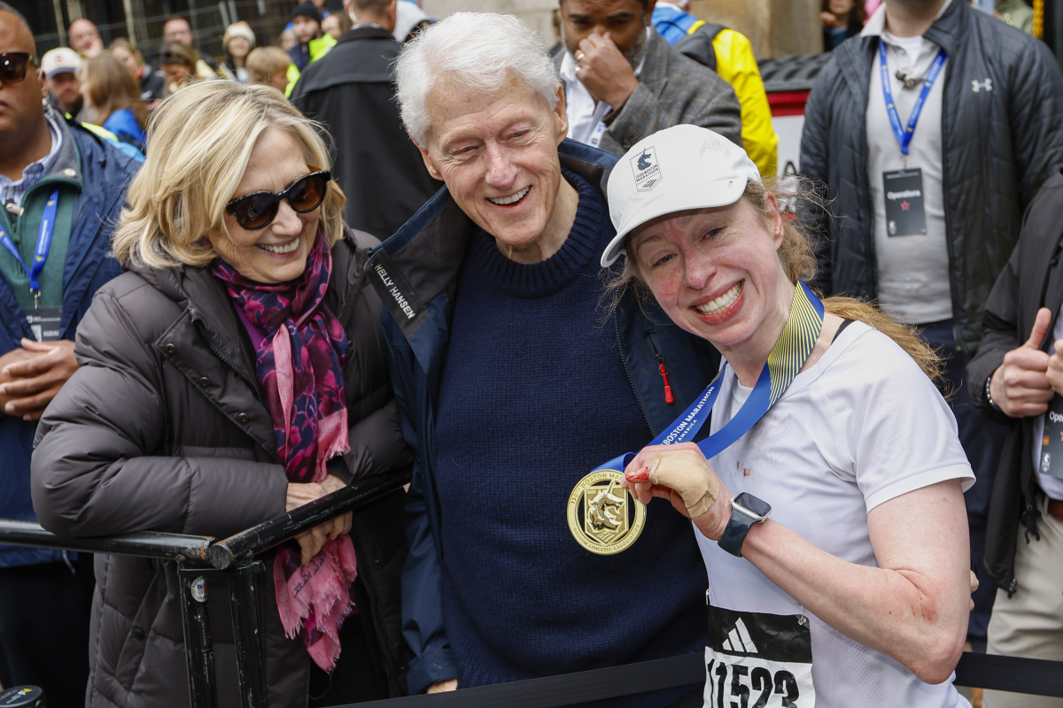 빌 클린턴(가운데) 전 미국 대통령과 힐러리 클린턴(왼쪽) 전 미 국무장관 부부가 21일(한국시간) 미국 매사추세츠주 보스턴에서 열린 보스턴 마라톤 결승선 근처에서 완주 메달을 목에 건 딸 첼시를 축하하고 있다. 보스턴 EPA 연합뉴스