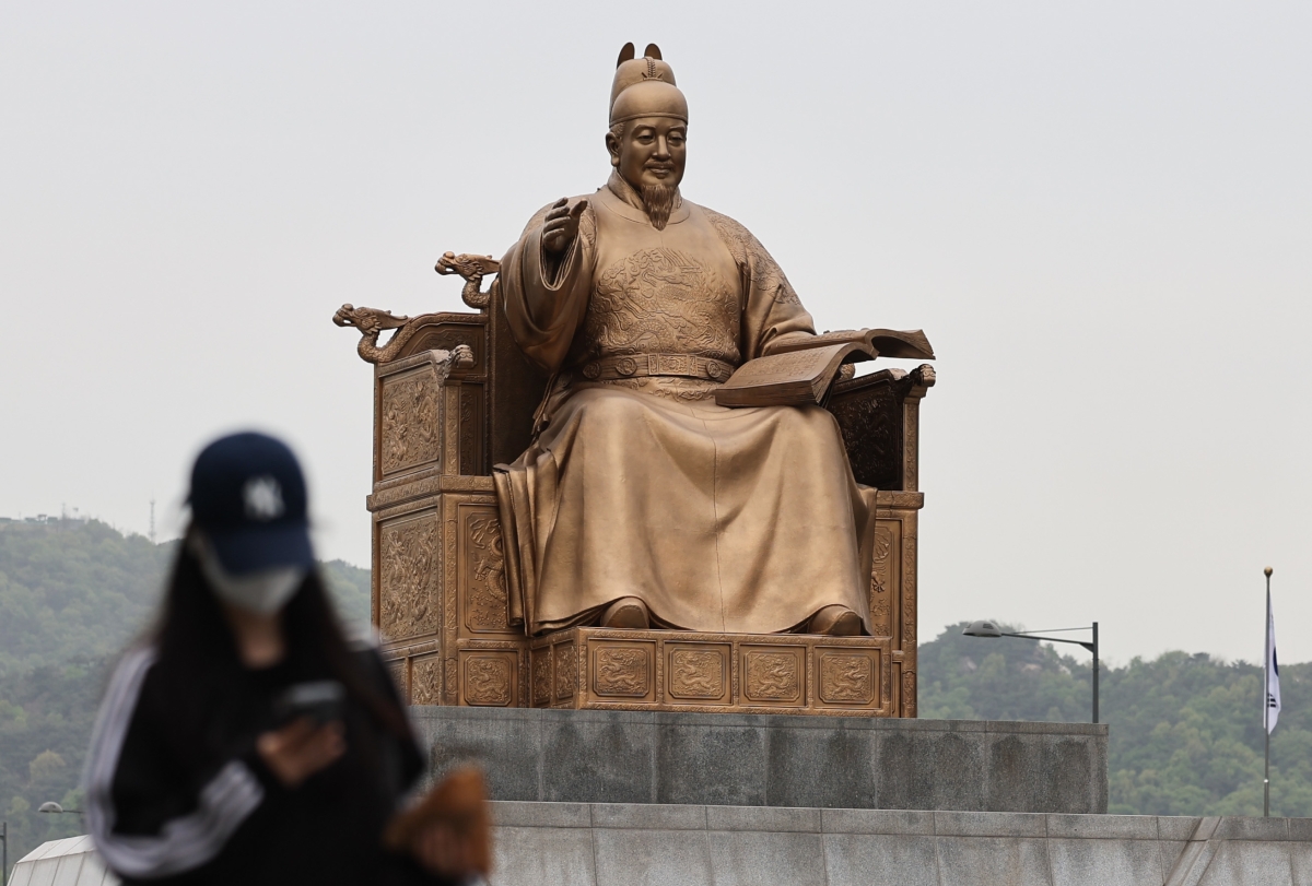 잔존 황사의 영향으로 미세먼지가 ‘나쁨’ 수준을 보인 22일 오전 서울 종로구 광화문광장에서 시민이 마스크를 착용한 채 이동하고 있다. 2026.4.22 뉴스1