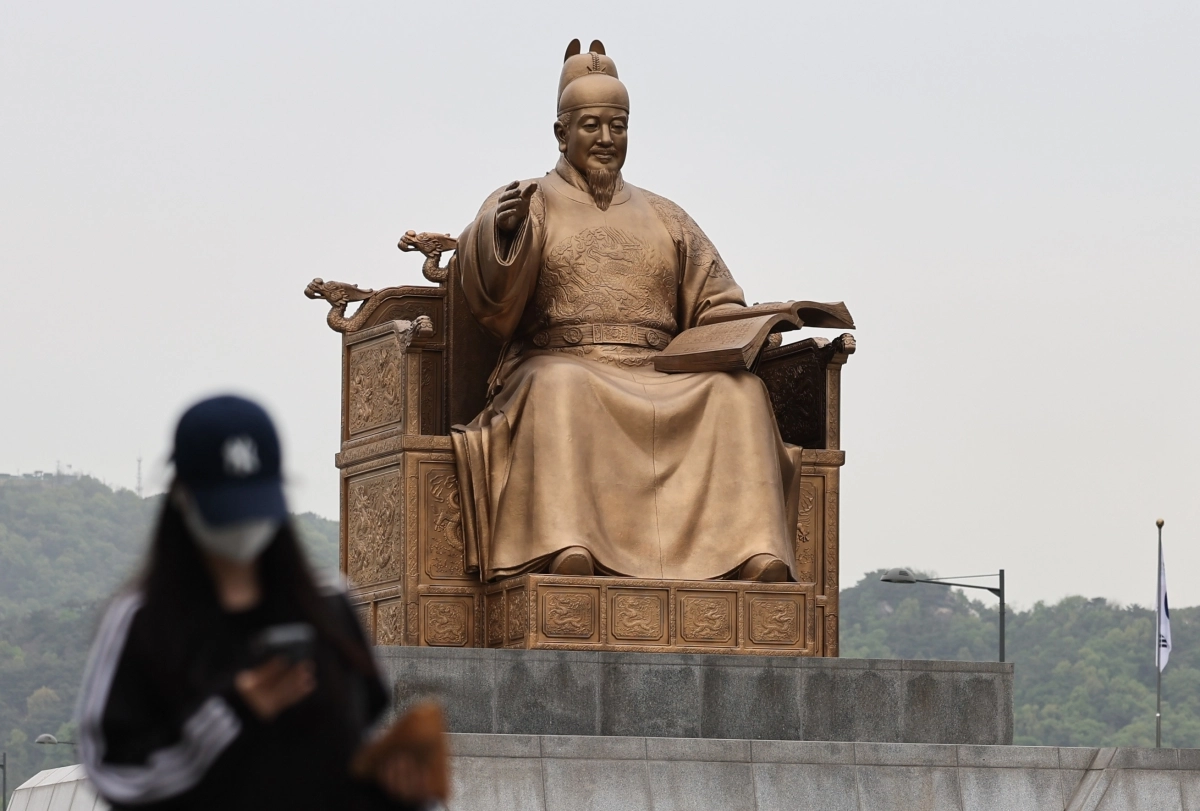 잔존 황사의 영향으로 미세먼지가 ‘나쁨’ 수준을 보인 22일 오전 서울 종로구 광화문광장에서 시민이 마스크를 착용한 채 이동하고 있다. 2026.4.22 뉴스1