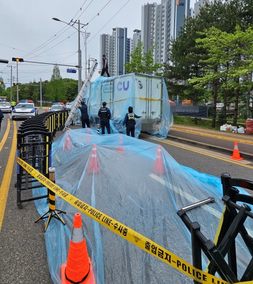 22일 경남 진주시 정촌면 CU 진주물류센터 앞 민주노총 화물연대 조합원이 사망한 사고 현장 보존을 위해 조합원과 경찰이 방수포 작업을 하고 있다. 2026.4.22. 뉴스1