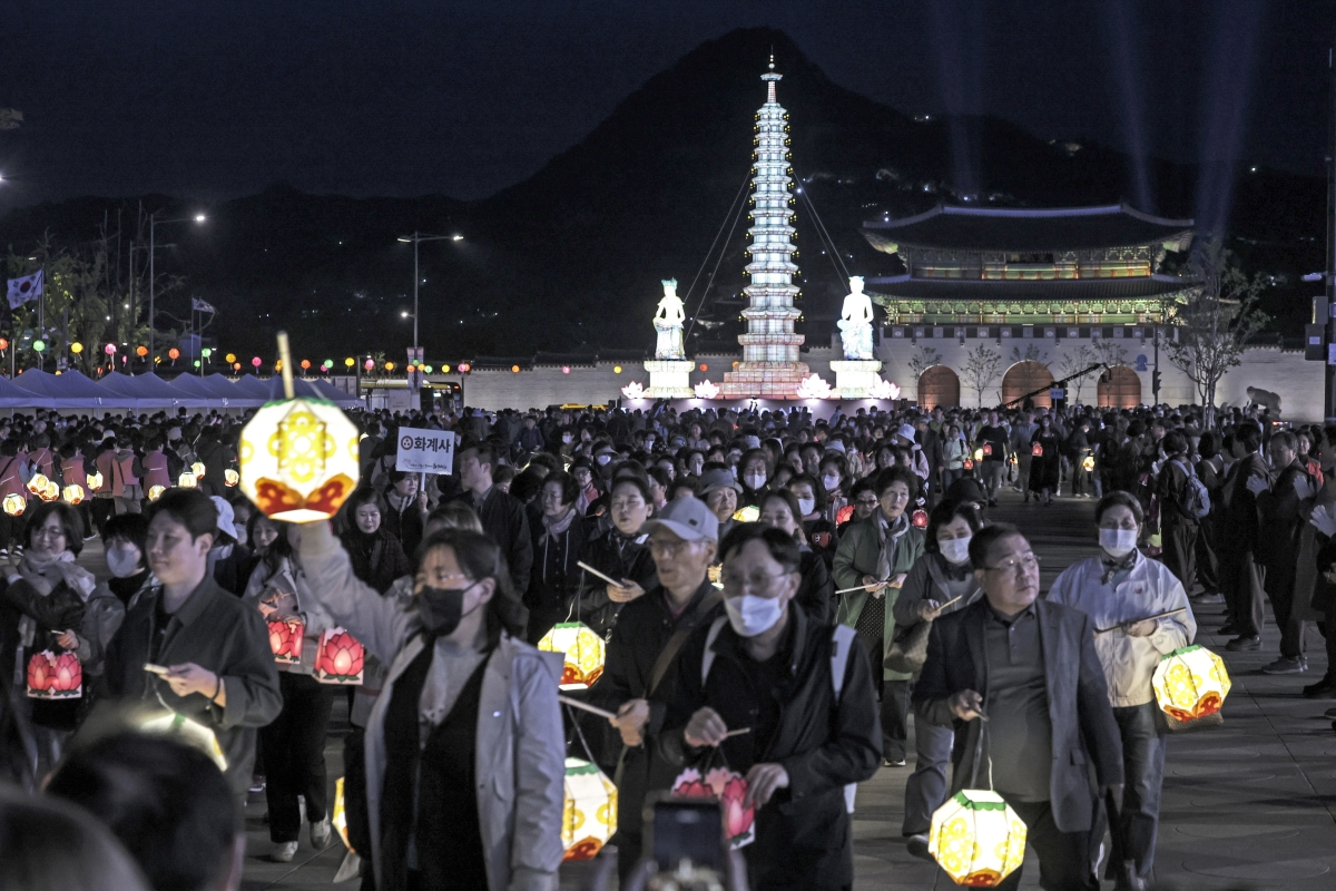 부처님오신날을 앞두고 22일 서울 광화문 광장에 불을 밝힌 보현사 탑등 주변에서 시민들이 탑돌이를 하고 있다. 뉴시스.