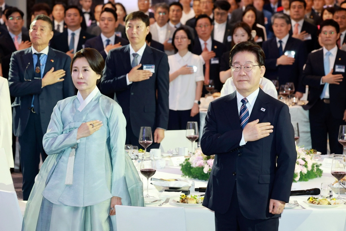 베트남을 국빈 방문 중인 이재명 대통령과 김혜경 여사가 22일(현지시간) 하노이의 한 호텔에서 열린 동포간담회에서 국기에 경례하고 있다. 2026.4.22 연합뉴스