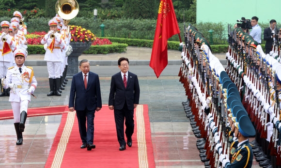 이재명 대통령과 또 럼 베트남 공산당 서기장 겸 국가주석이 22일(현지시간) 하노이 주석궁에서 열린 공식환영식에서 의장대 사열을 하고 있다. 2026.4.22 <br>연합뉴스