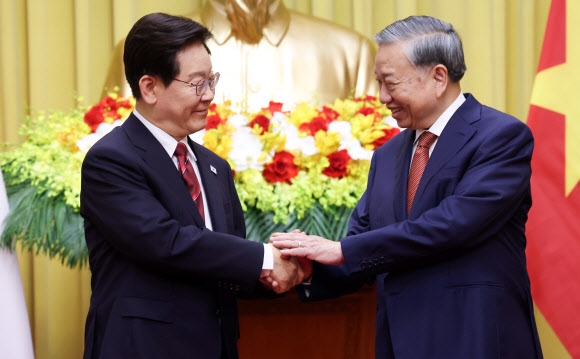 이재명 대통령과 또 럼 베트남 공산당 서기장 겸 국가주석이 22일(현지시간) 하노이 주석궁에서 기념촬영 중 악수하고 있다. 2026.4.22<br>연합뉴스