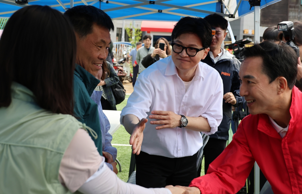 부산 북구갑 국회의원 보궐선거 국민의힘 후보군인 박민식(오른쪽) 전 국가보훈부 장관과 무소속으로 출마한 한동훈(오른쪽 두 번째) 전 국민의힘 대표가 26일 구포초에서 열린 동문 운동회에 나란히 참석해 주민들과 악수하고 있다. 부산 연합뉴스