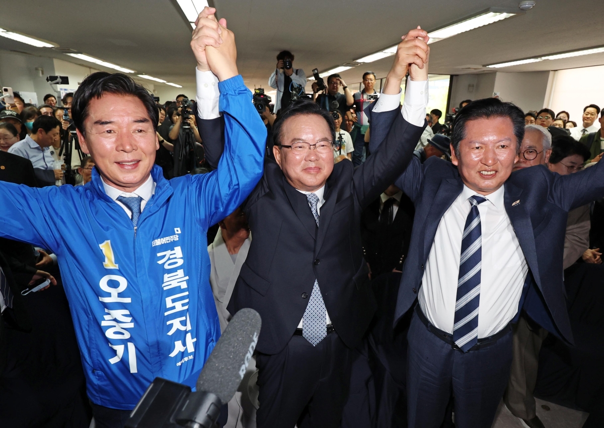 26일 대구 달서구 두류역 인근에 마련된 더불어민주당 대구시장 후보 김부겸 전 국무총리 선거사무소 개소식에서 왼쪽부터 민주당 경북도지사 후보인 오중기 전 청와대 선임행정관과 김 전 총리, 정청래 민주당 대표가 손을 맞잡고 있다. 연합뉴스