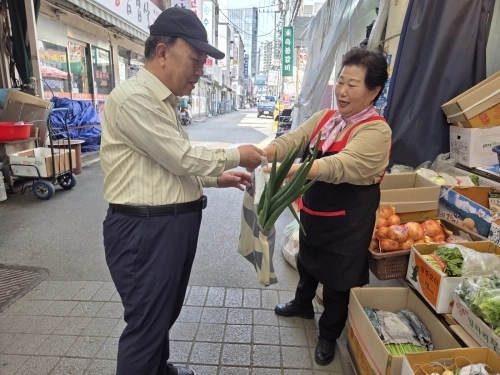 지난 15일 서울 송파구 잠실동 새마을시장을 찾은 구민이 구에서 제공한 폐현수막 친환경 장바구니에 구매한 물건을 담고 있다. 송파구 제공