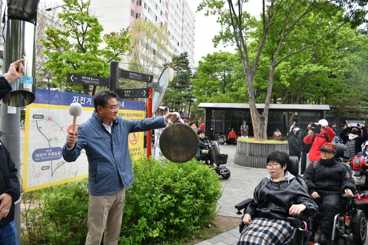 오승록(왼쪽) 서울 노원구청장이 지난 22일 경춘선 숲길에서 열린 장애인의 날 기념 걷기행사에서 징을 치면서 행사의 시작을 알리고 있다. 노원구 제공