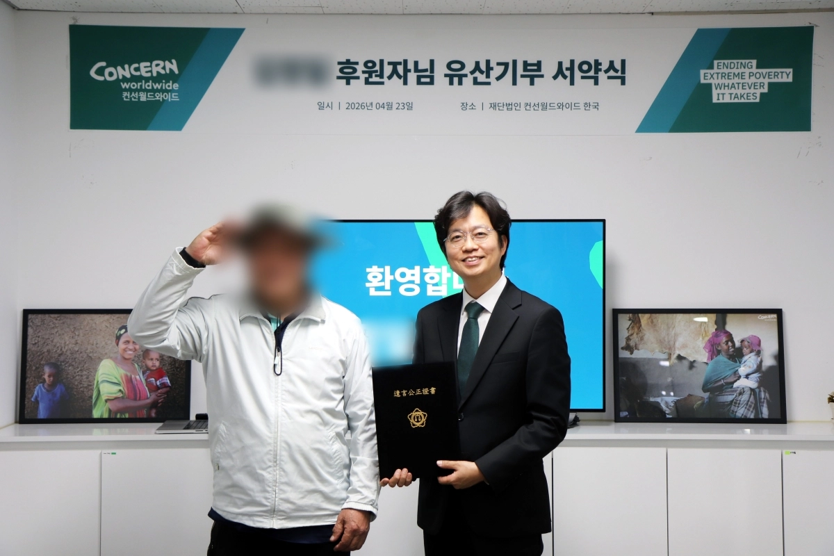 지난 4월 23일 컨선월드와이드 사무소에서 열린 유산기부 서약식에서 후원자(좌)와 컨선월드와이드 이준모 대표(우)가 전달한 유언공정증서를 들고 기념 촬영을 하고 있다.
