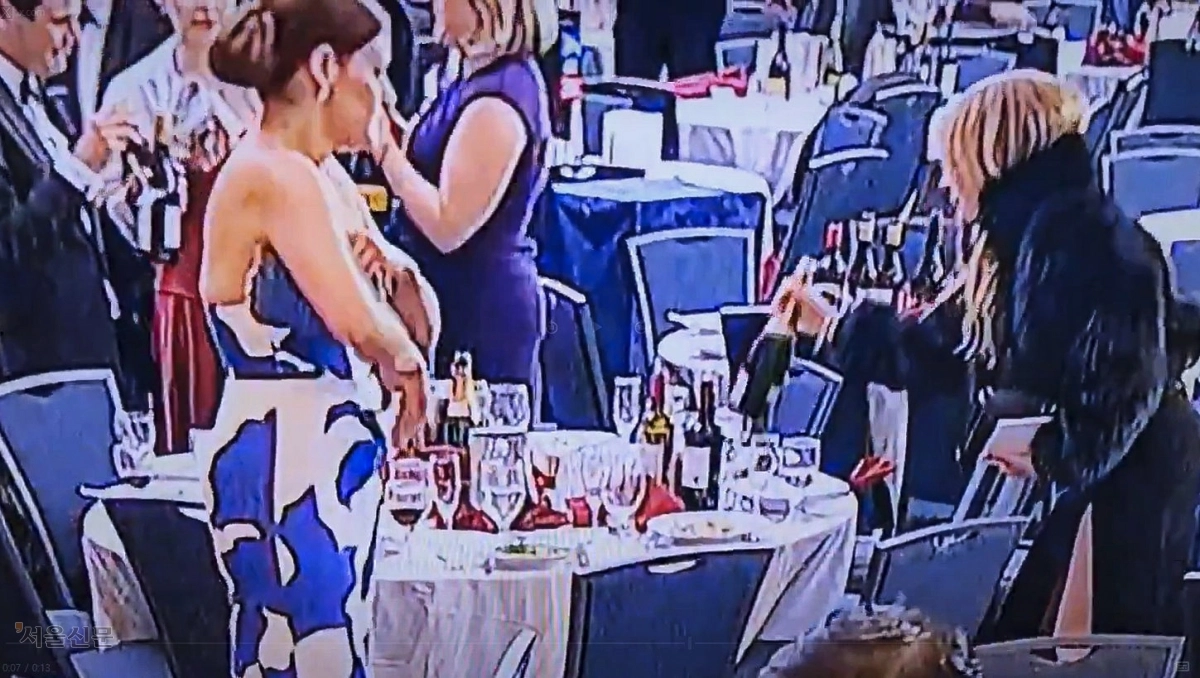 한 여성이 행사장 테이블에 있는 와인을 챙기는 모습. 엑스(X) 캡처