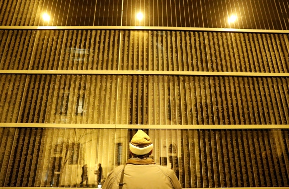 2019년 1월 27일 헝가리 부다페스트에 있는 홀로코스트 기념관에서 열린 ‘국제 홀로코스트 추모의 날’ 행사에서 한 남성이 희생자들의 이름이 새겨진 벽 앞에 서 있는 모습.  서울신문 DB