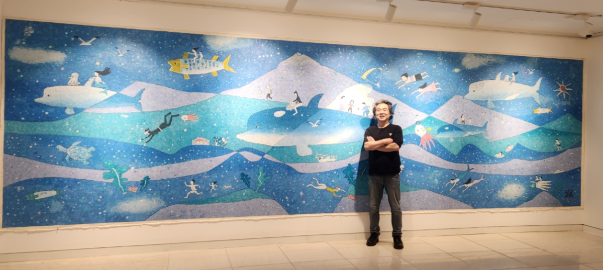 ‘고래 화가’ 김품창 작가가 29일부터 세종뮤지움갤러리 1관에서 열리는 제주 25년 회고전에서 7~8m 대작 앞에서 포즈를 취하고 있다. 작가 제공