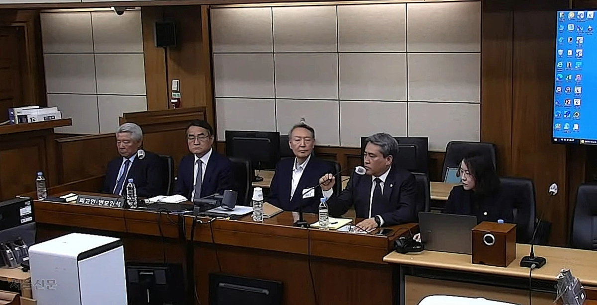 윤석열(가운데) 전 대통령이 29일 서울고등법원에서 열린 특수공무집행방해, 직권남용 권리행사방해 등 사건의 항소심 선고 공판에 출석해 있다. ﻿ 유튜브 캡처